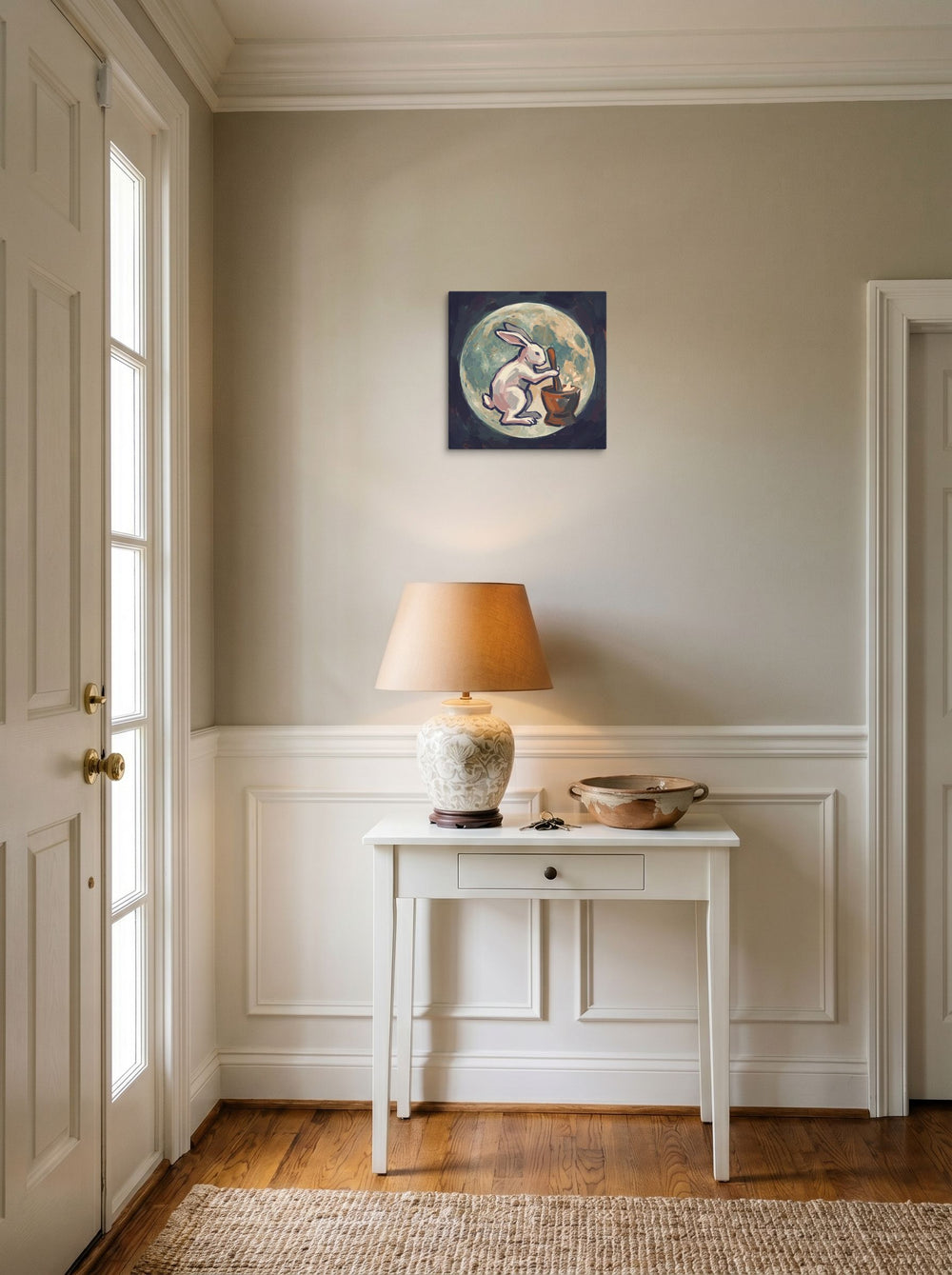 A 12x12 inch canvas version of 'Alchemist Moon Rabbit', Folk art wall art, set against a bright entryway wall.