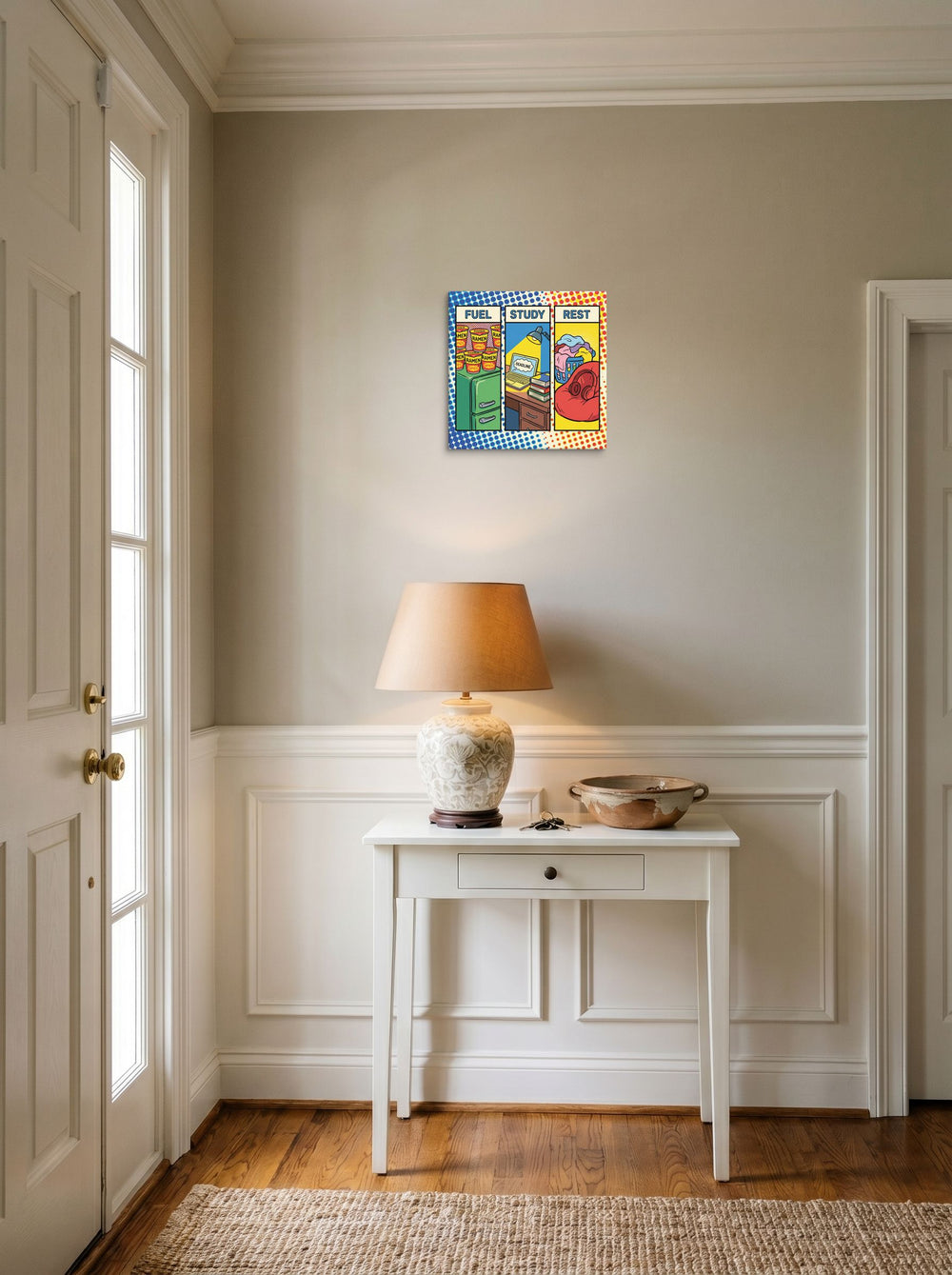 A 12x12 inch canvas Pop art print of 'The College Triad' hanging in an entryway near a console.
