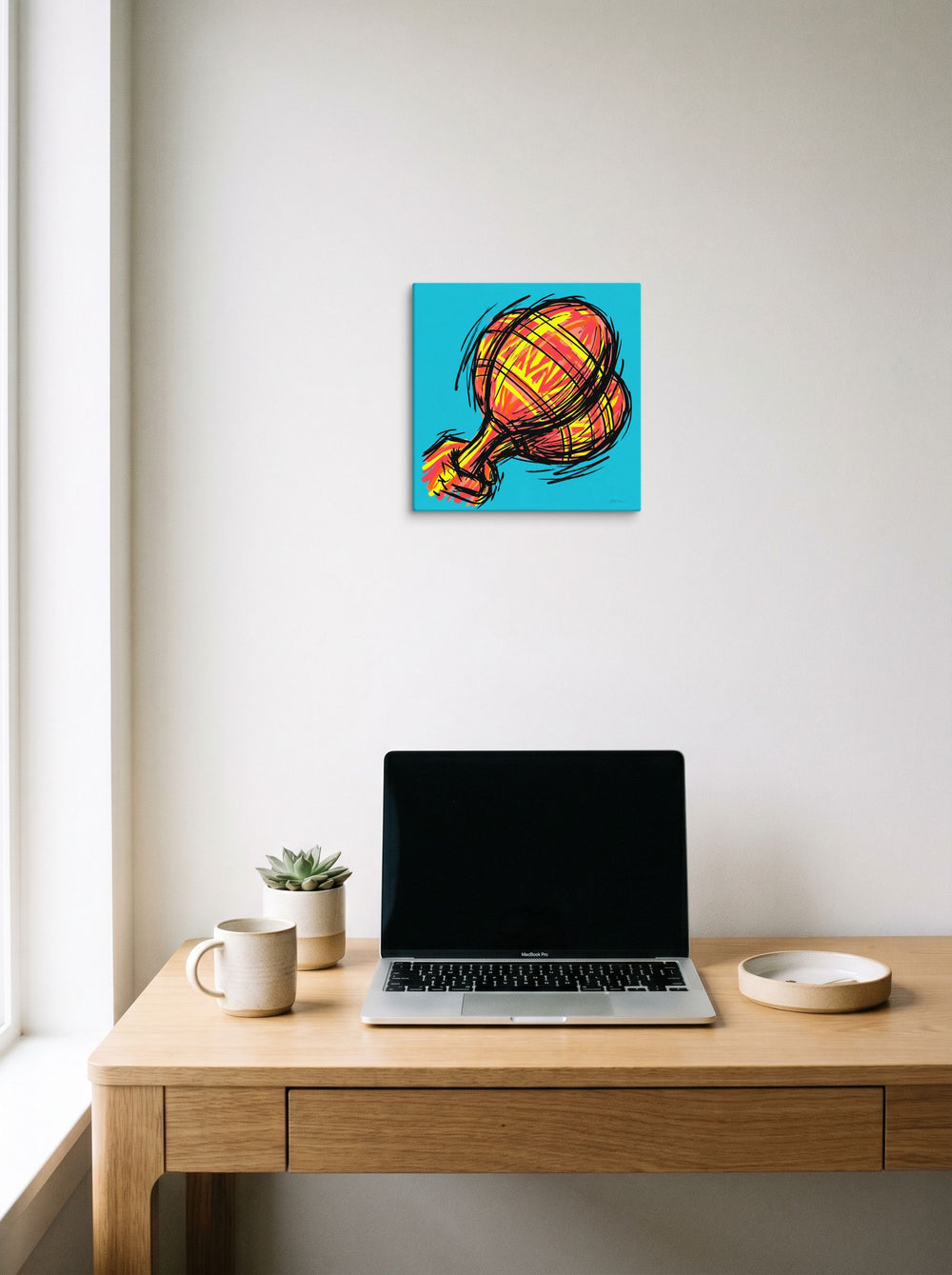A 12x12 inch canvas Pop art print of 'Scribbled Ascent' hanging above a worktable with a laptop.