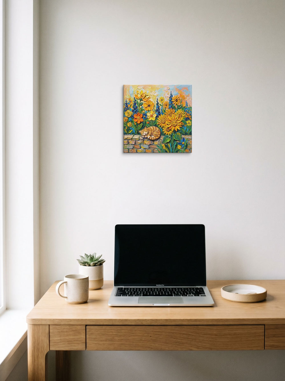 A 12x12 inch canvas Post-Impressionism print of 'Feline Slumber Among Sunflowers' hanging above a worktable with a laptop.