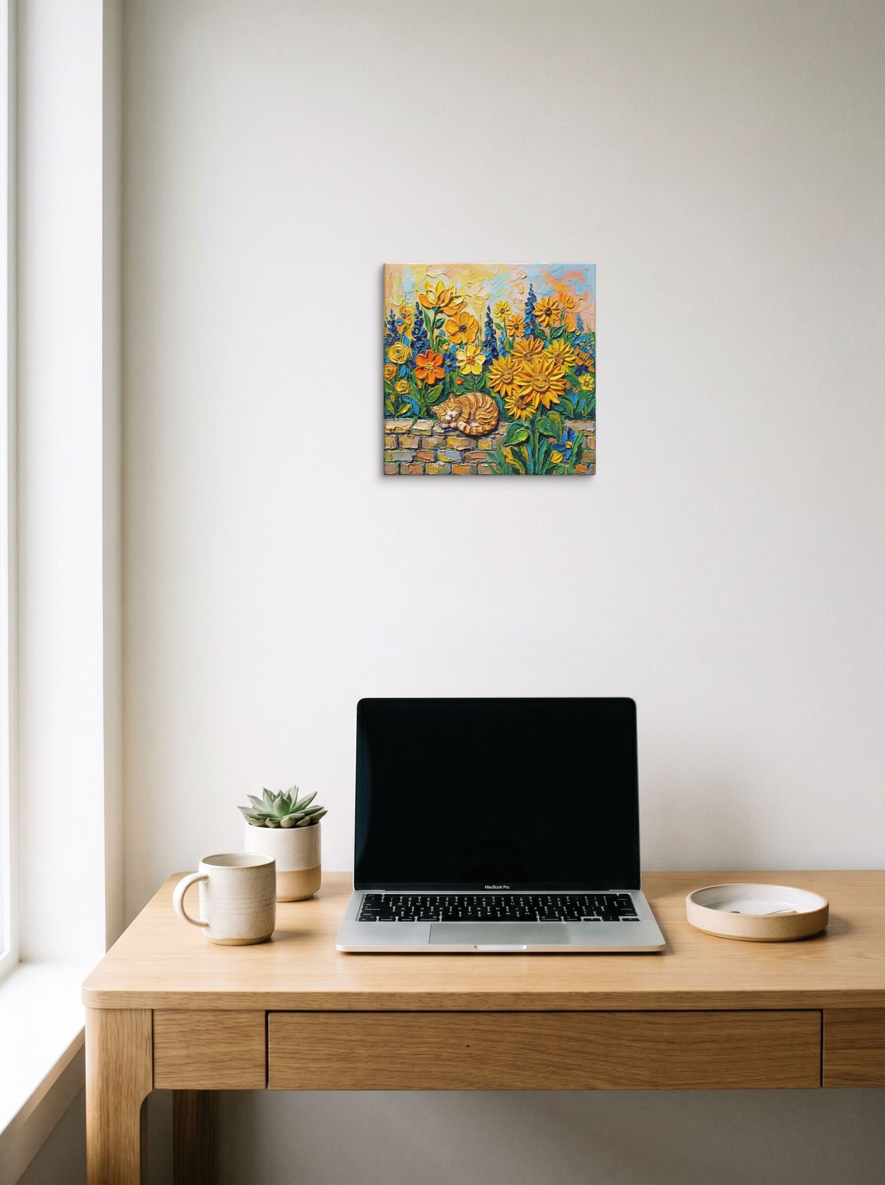 A 12x12 inch canvas Post-Impressionism print of 'Feline Slumber Among Sunflowers' hanging above a worktable with a laptop.