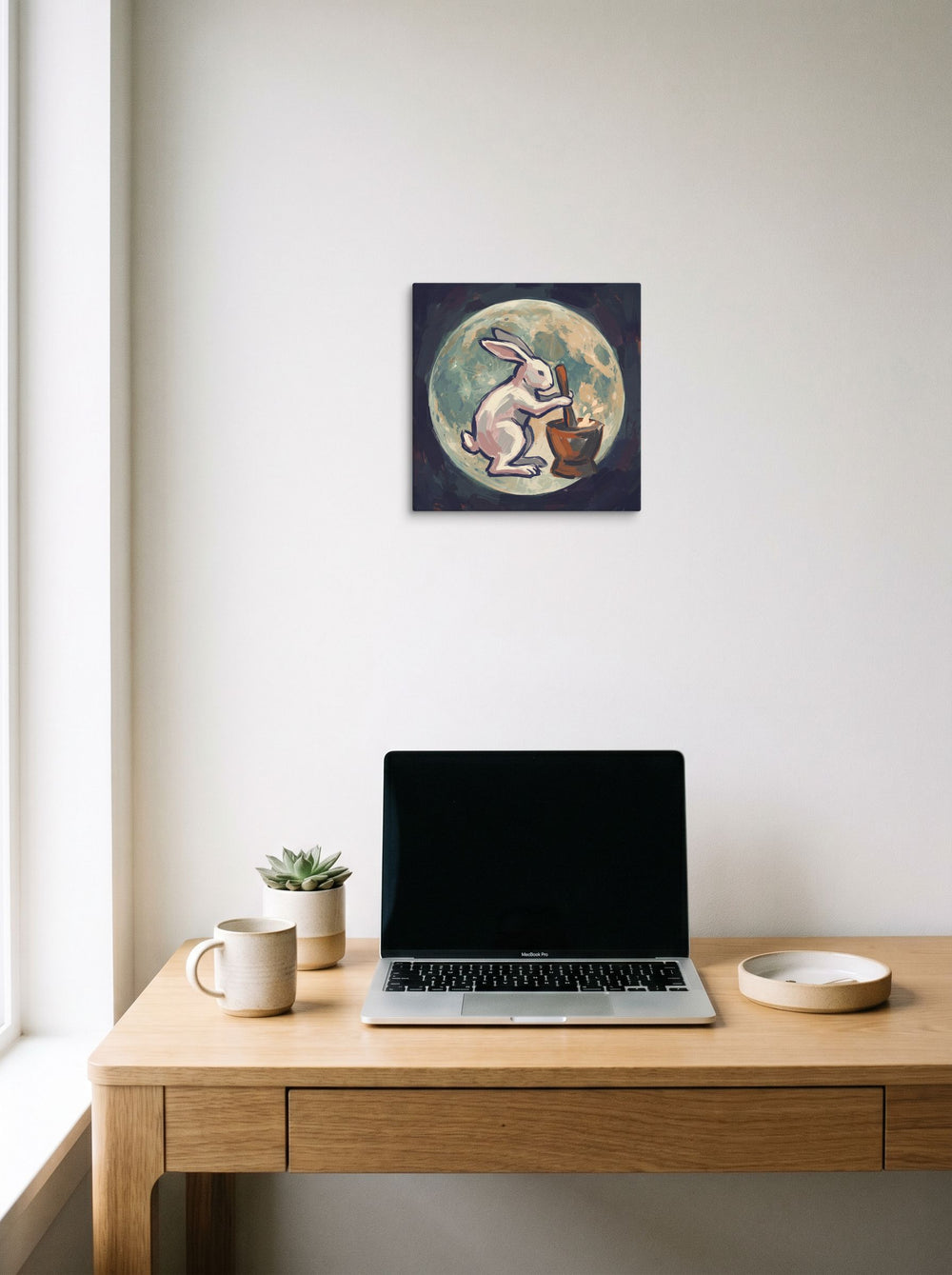 'Alchemist Moon Rabbit' displayed over a compact desk setup. A 12x12 inch canvas Folk art print.