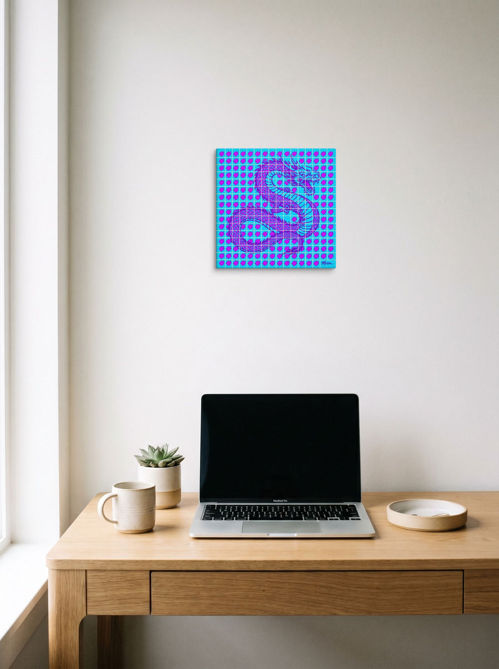 A 12x12 inch canvas Pop art print of 'Neon Dragon Grid' hanging above a worktable with a laptop.