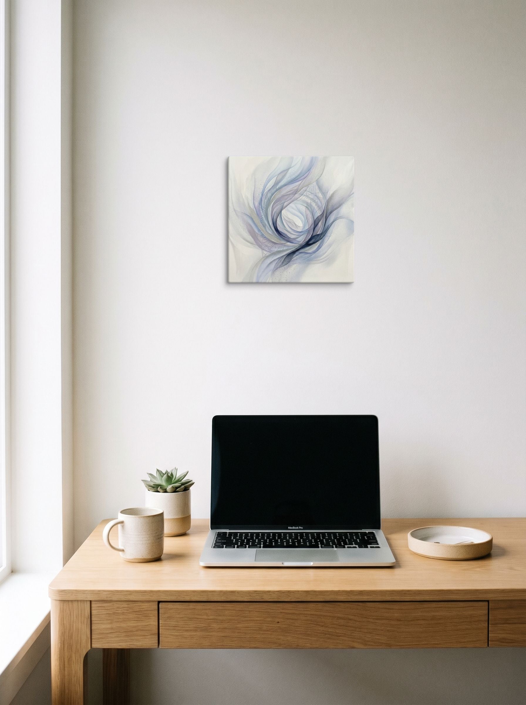A 12x12 inch canvas Abstract art print of 'Ethereal Whispers in the Vortex' hanging above a worktable with a laptop.