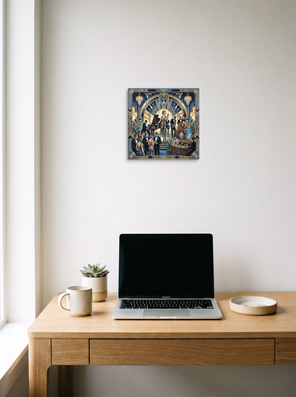 A 12x12 inch canvas Art Deco print of 'The Jazz Age Symphony' hanging above a worktable with a laptop.