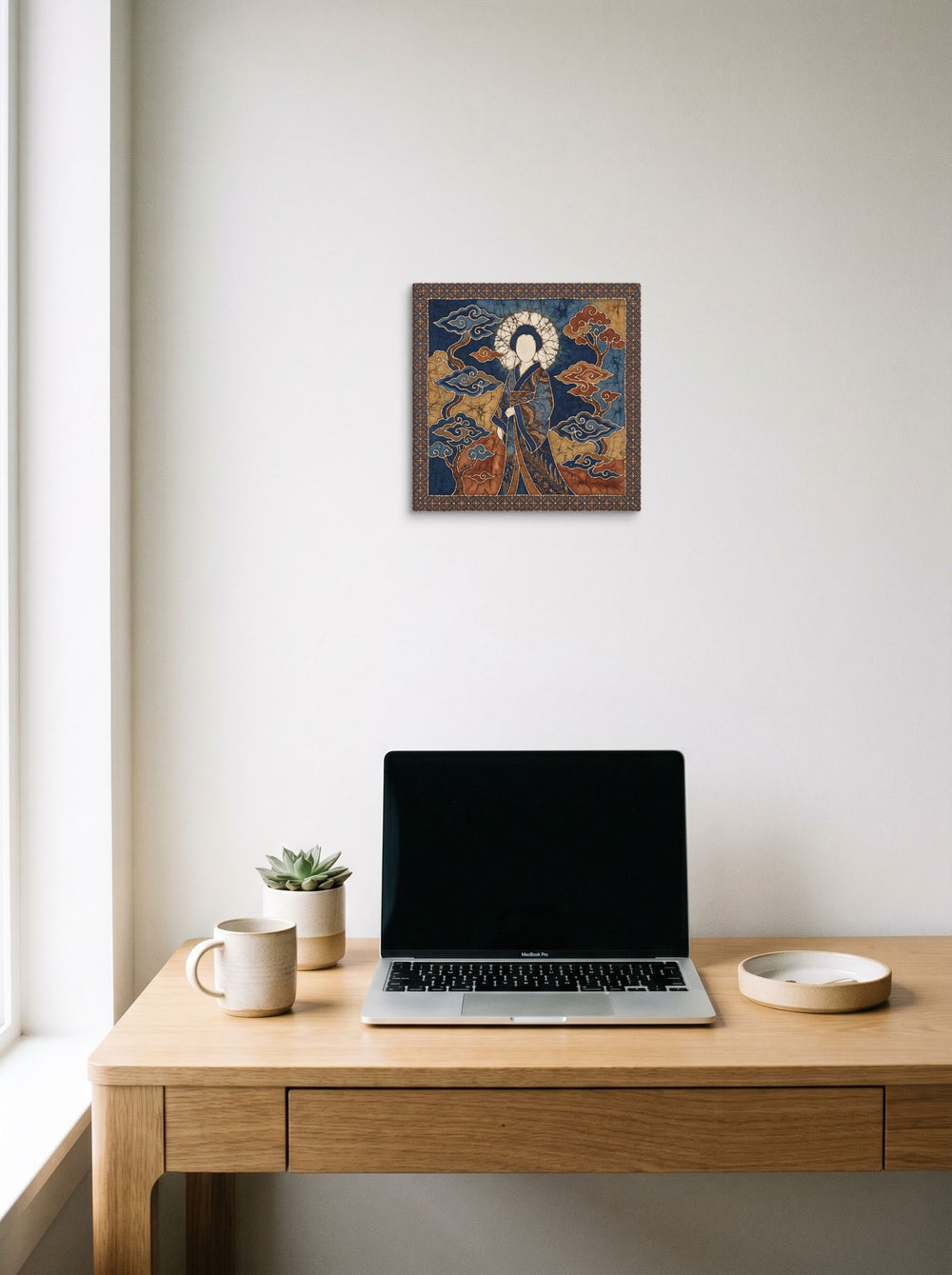 Mockup of 'Amaterasu in Batik' as a 12x12 inch canvas print, styled above a home-office workspace.