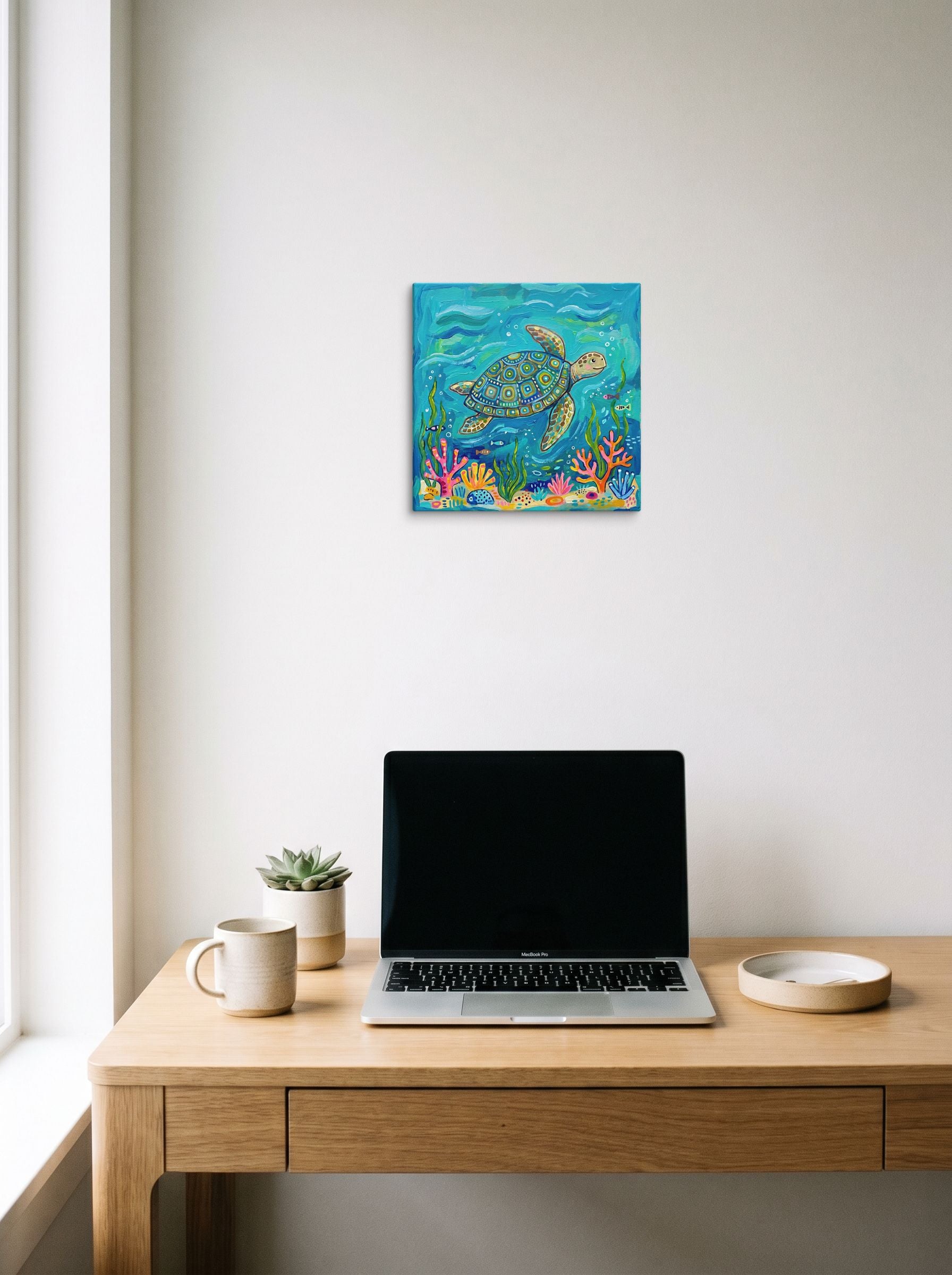 A 12x12 inch canvas Naive art print of 'The Painted Sea Turtle' hanging above a worktable with a laptop.