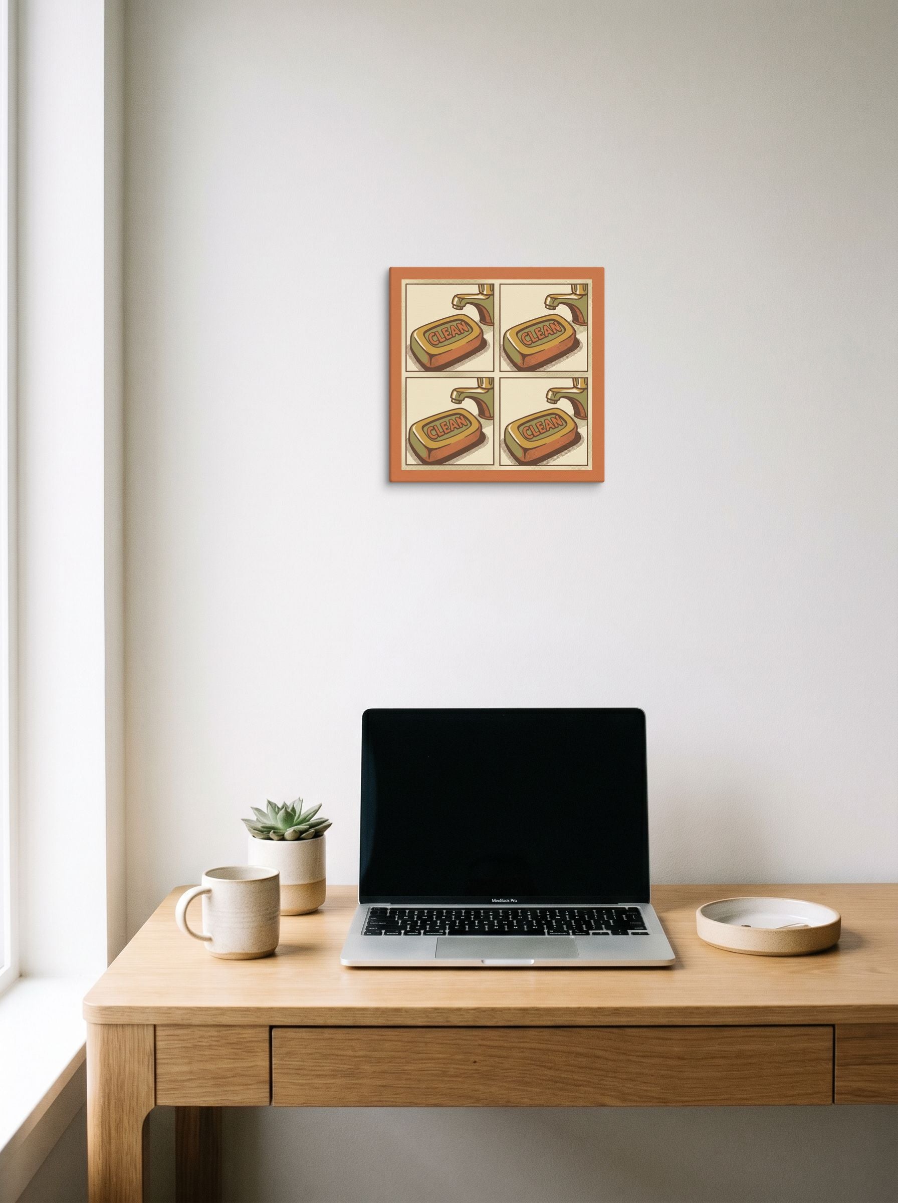 A 12x12 inch canvas Pop art print of 'Clean Repetition' hanging above a worktable with a laptop.