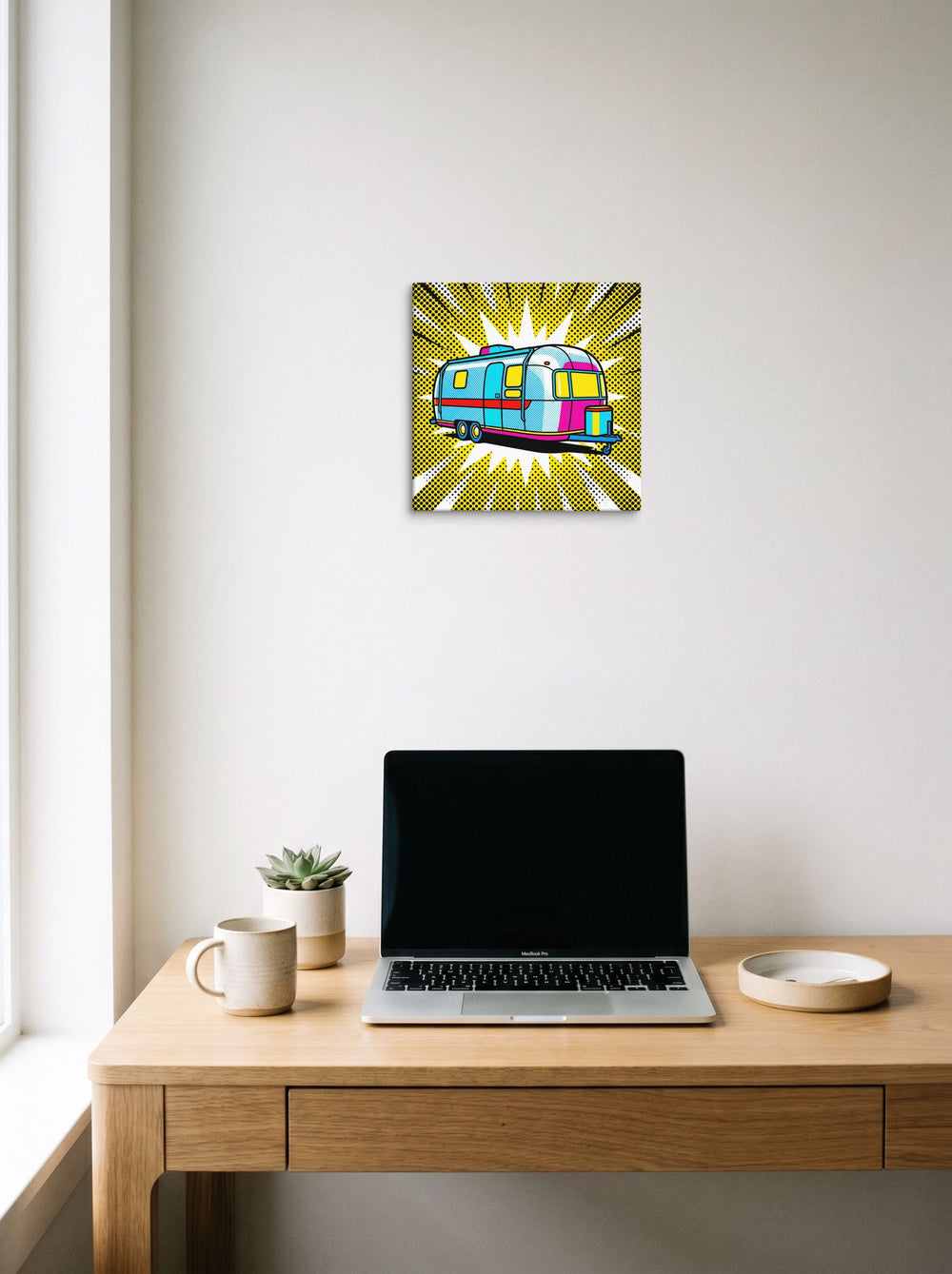 A 12x12 inch canvas Pop art print of 'Pop Art Camper' hanging above a worktable with a laptop.