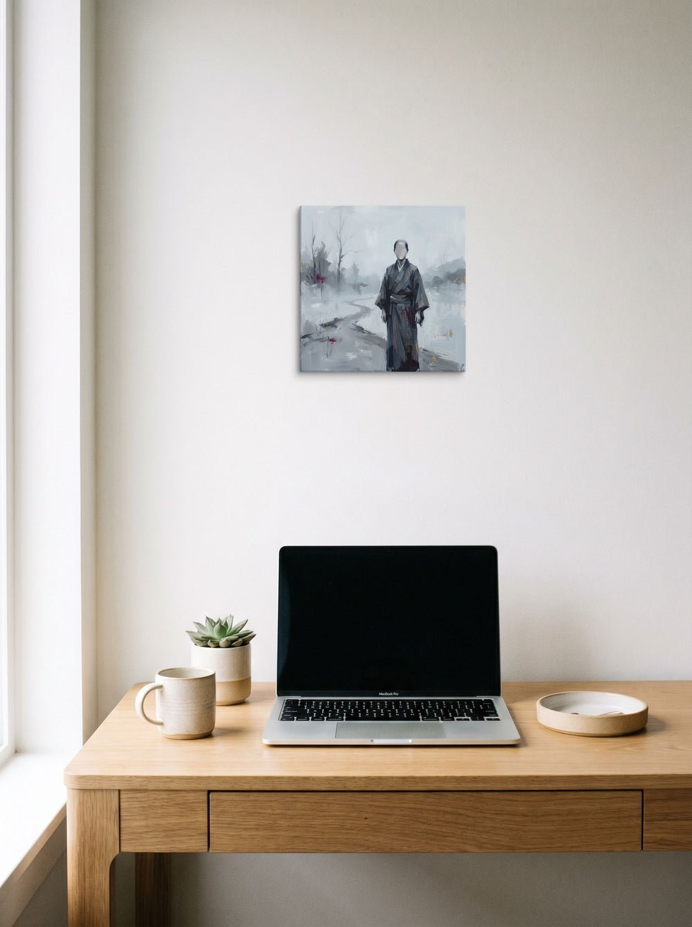A 12x12 inch canvas Japanese art print of 'The Faceless Wanderer', hanging above a worktable with a laptop.