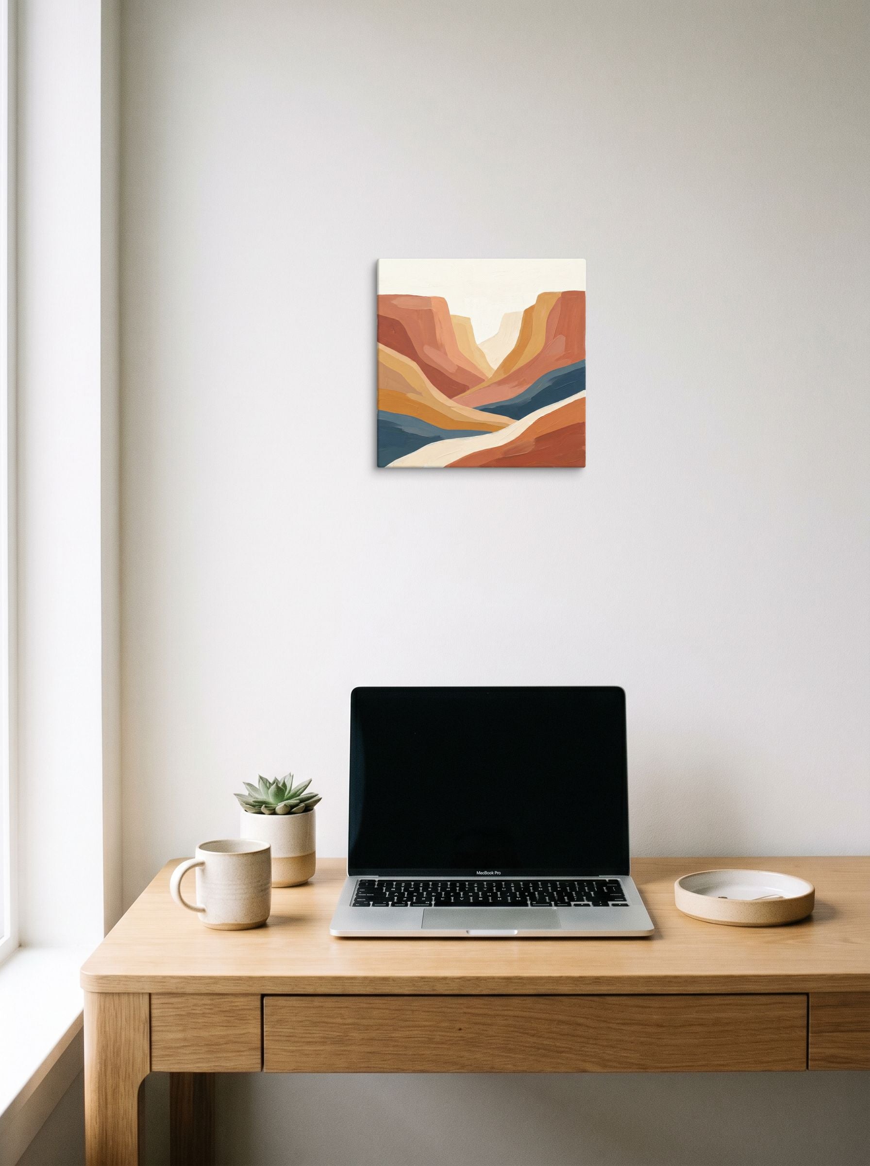 A 12x12 inch canvas Minimalism,American Scene Painting print of 'Canyon River' hanging above a worktable with a laptop.