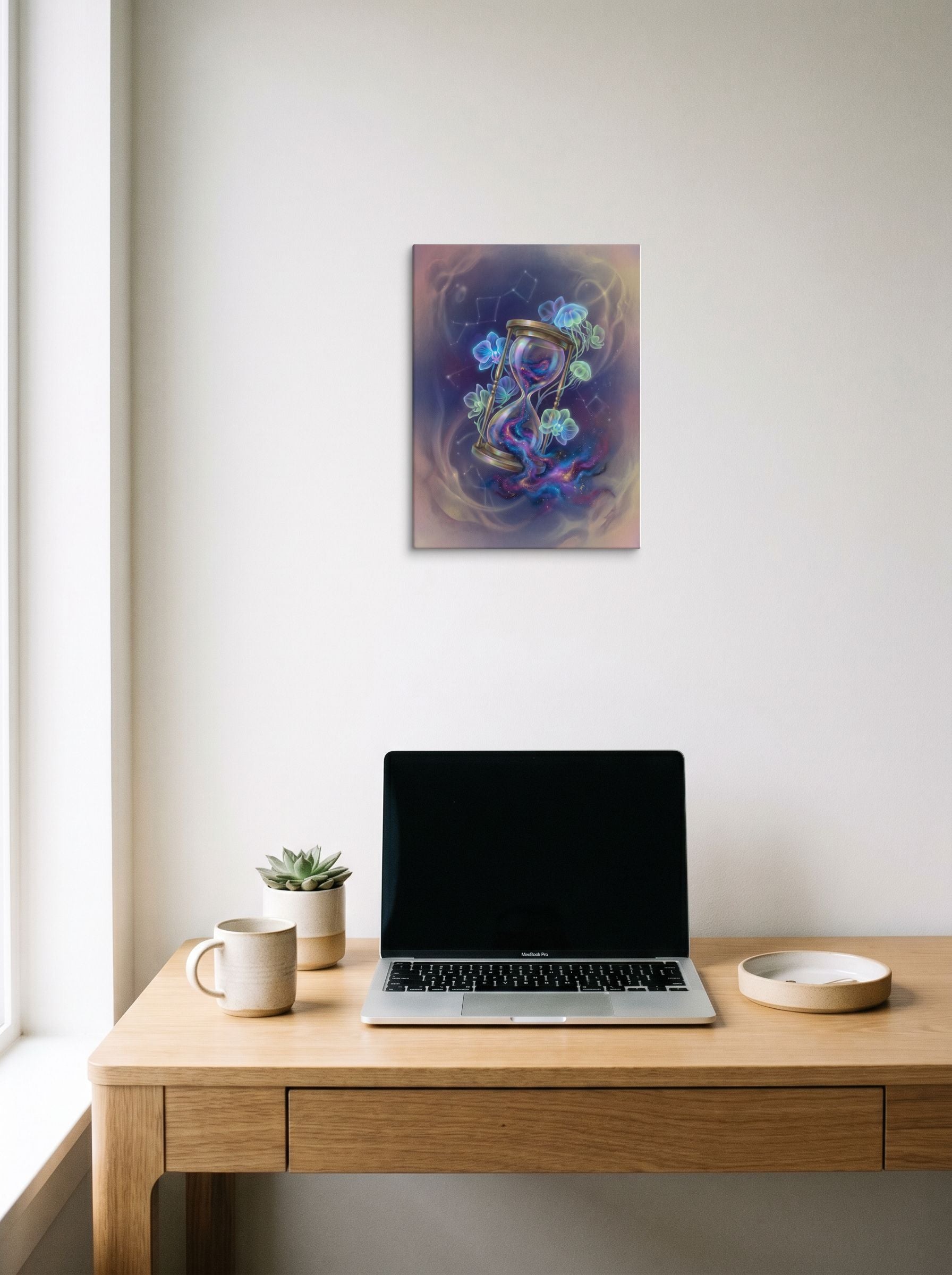 A 12x16 inch canvas Magic realism print of 'Sands of the Nebula' hanging above a worktable with a laptop.