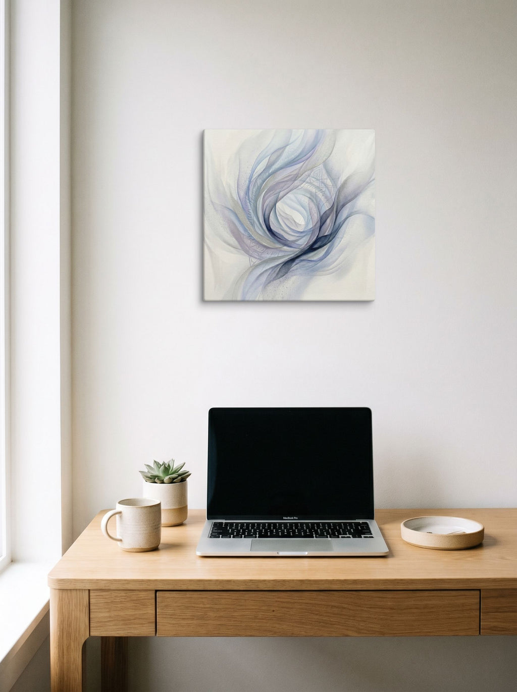 A 16x16 inch canvas Abstract art print of 'Ethereal Whispers in the Vortex' hanging above a worktable with a laptop.