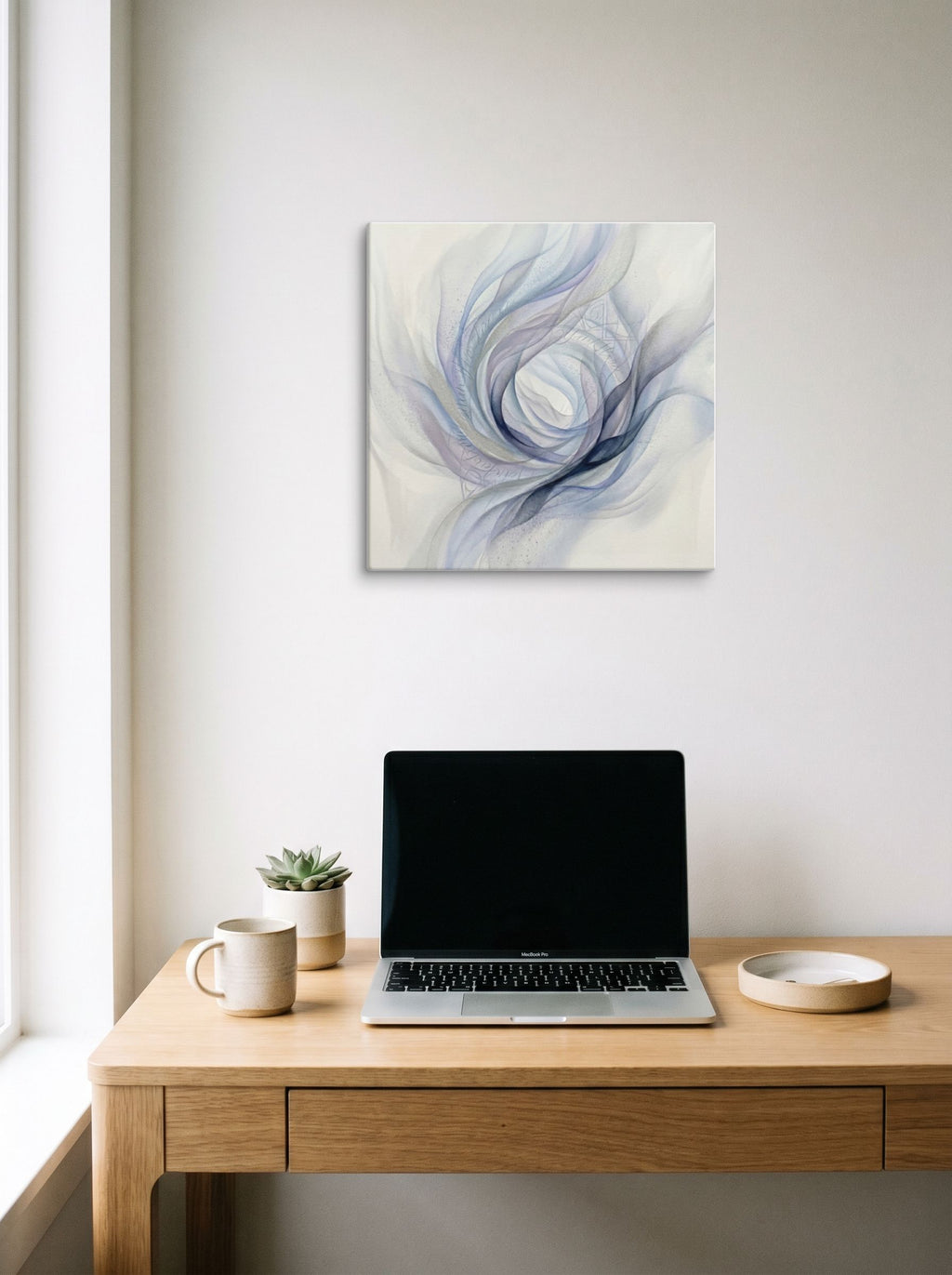 A 18x18 inch canvas Abstract art print of 'Ethereal Whispers in the Vortex' hanging above a worktable with a laptop.