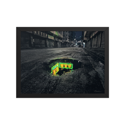 'Neon Puddle' — a Photorealism,Street art print. A dark, empty city street with closed shutters features a puddle in the foreground reflecting a bright green and yellow neon sign, perfect for a modern office or man cave.