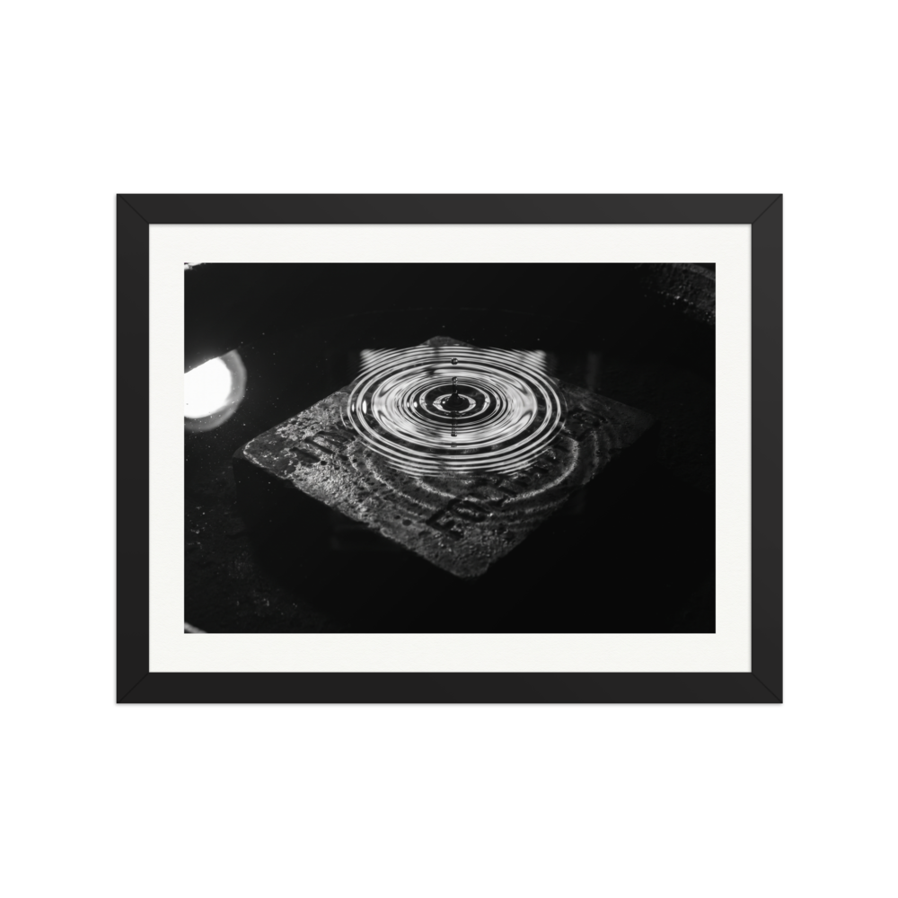 'Concentric Resonance' — a Art photography print. A dramatic black and white photograph capturing concentric water ripples above a textured stone, well suited for a modern office or living room.