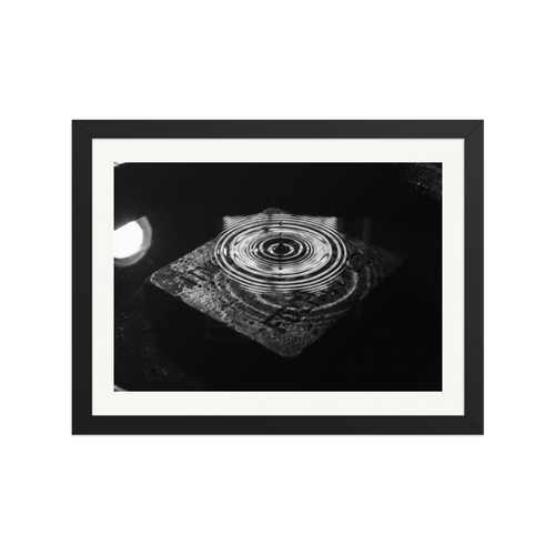'Concentric Resonance' — a Art photography print. A dramatic black and white photograph capturing concentric water ripples above a textured stone, well suited for a modern office or living room.