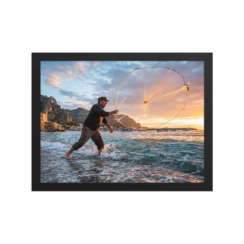 'Casting the Dawn' — a Art photography print. A dynamic photograph of a fisherman casting a circular net that catches golden sunrise light over the sea, ideal for a living room or study.
