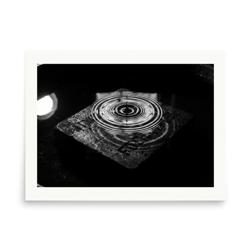 'Concentric Resonance' — a Art photography print. A dramatic black and white photograph capturing concentric water ripples above a textured stone, well suited for a modern office or living room.