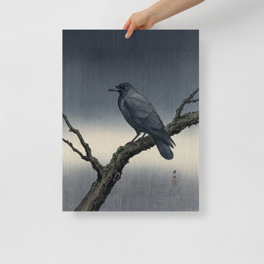 'Solitary Raven at Dusk' — a Shin hanga print. A dark raven perches on a mossy winter branch against a textured gray woodblock background, bringing a calm aesthetic to an office.