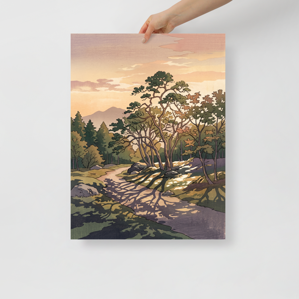 A winding forest path dappled with tree shadows leads toward distant mountains under a warm peach evening sky, ideal for a tranquil living room. A calmness piece titled 'Dappled Sunset Path'.