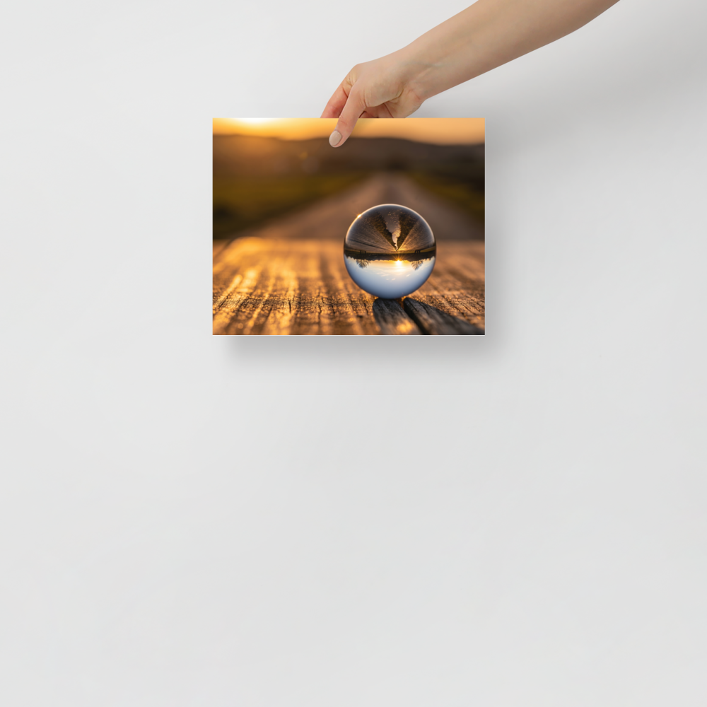 'Inverted Sunset' — a Surrealism print. A glass sphere resting on wood, refracting an upside-down golden sunset landscape.