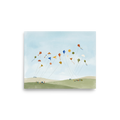 'Kite Festival' — a Minimalism,Naive art print. A playful minimalist painting showing numerous colorful geometric kites flying high in a light blue sky, held by tiny figures on soft green and beige hills. Perfect for a nursery or playroom.