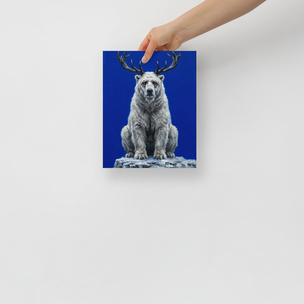 'The Horned Bear' — a Surrealism,Expressionism print. A white polar bear with deer antlers sitting on a snowy rock against a bright blue background, perfect for an eclectic living room.