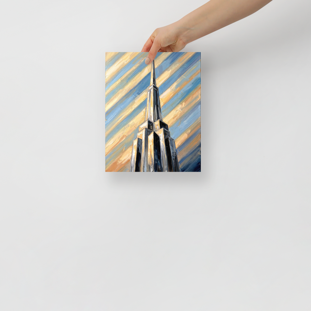 'The Metropolis Spire' — a Art Deco print. An oil painting of a towering Art Deco skyscraper piercing a dynamic, diagonal striped sky of blue and gold, great for an office or study.