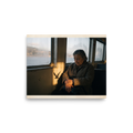 'Shadow of the Gull' — a Art photography print. An elderly woman sits thoughtfully by a window in golden sunlight with a bird shadow cast beside her, ideal for a contemplative living room or study.