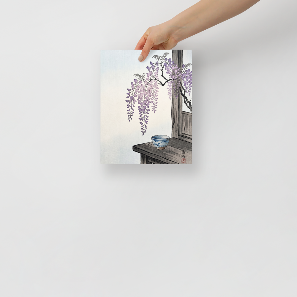 'Wisteria and Tea' — a Shin hanga print. Cascading purple wisteria blossoms hang above a traditional blue ceramic tea bowl on a rustic wooden table, ideal for a serene dining room.