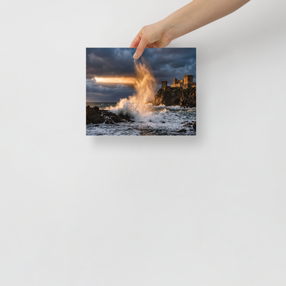'Citadel of the Waves', a Art photography wall art print. A dramatic photograph of a massive golden wave crashing against rocky cliffs below an ancient coastal castle under storm clouds, perfect for a living room or study.