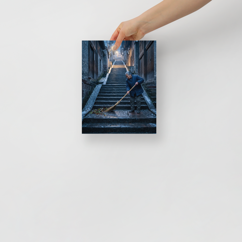 Fine art print 'Dawn on the Steps' in a Art photography style. An elderly woman sweeps stone stairs in a quiet atmospheric alleyway, bringing a sense of peaceful contemplation suited for a hallway.