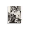 A detailed black and white pencil sketch of Taylor Swift playing an acoustic guitar in a cozy cable-knit sweater, ideal wall art for a calm bedroom. Available as the Realism art print 'Acoustic Reverie'.