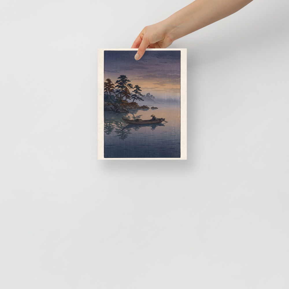 'Fisherman at Twilight', a Shin hanga wall art print. A lone fisherman sits in a wooden boat on a misty calm lake at twilight near pine-lined rocks, creating a tranquil atmosphere for a bedroom.