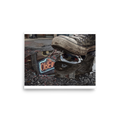 The Realism print 'Stuck in the Neon Rain'. A black high-top sneaker stepping on sticky gum over a puddle reflecting a neon open sign in an urban entryway.