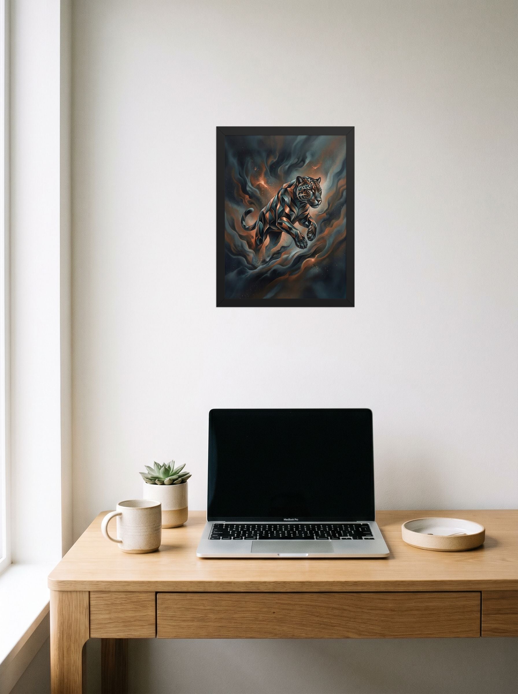 A 12x16 inch black framed Digital art print of 'Phantom Leap' hanging above a worktable with a laptop.