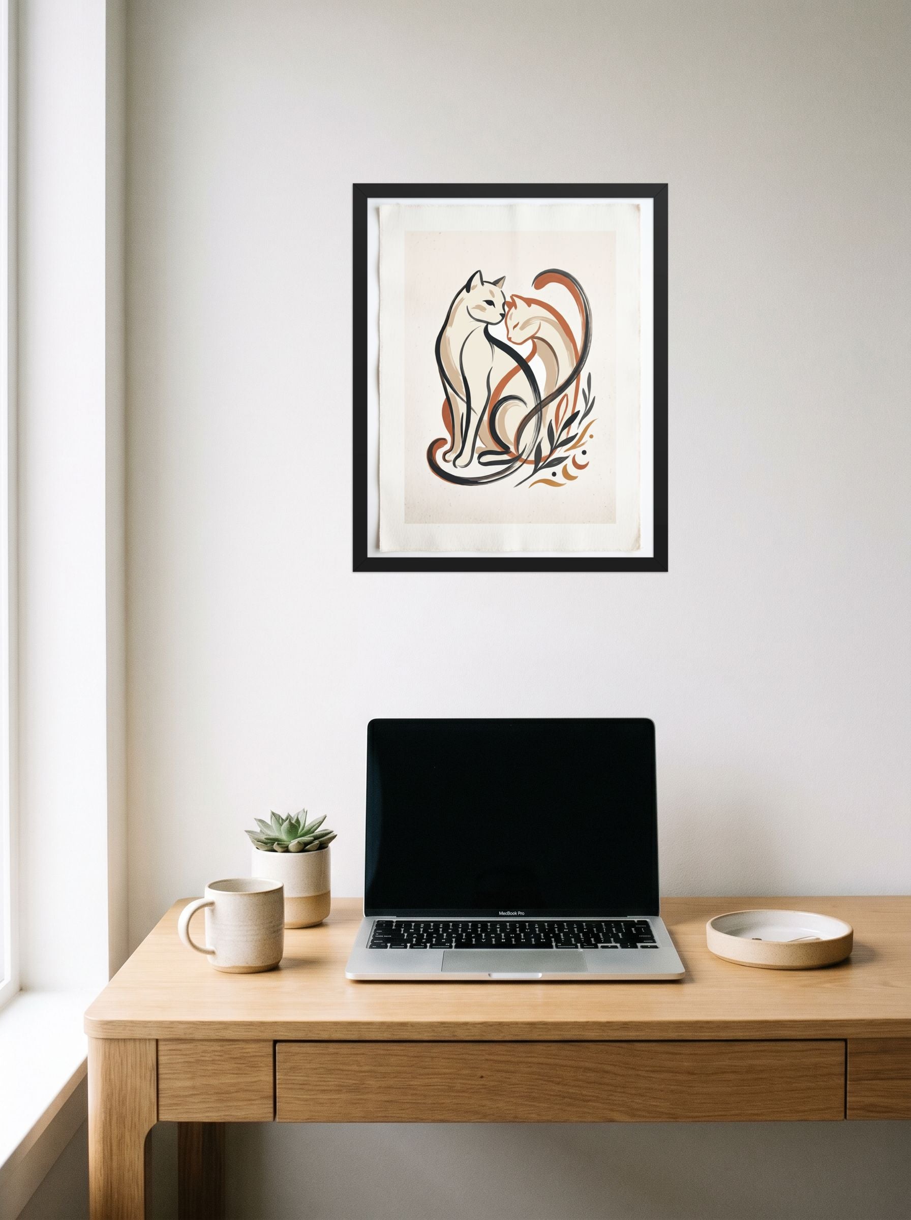 A 16x20 inch black framed Minimalism,Abstract art print of 'Feline Affection' hanging above a worktable with a laptop.