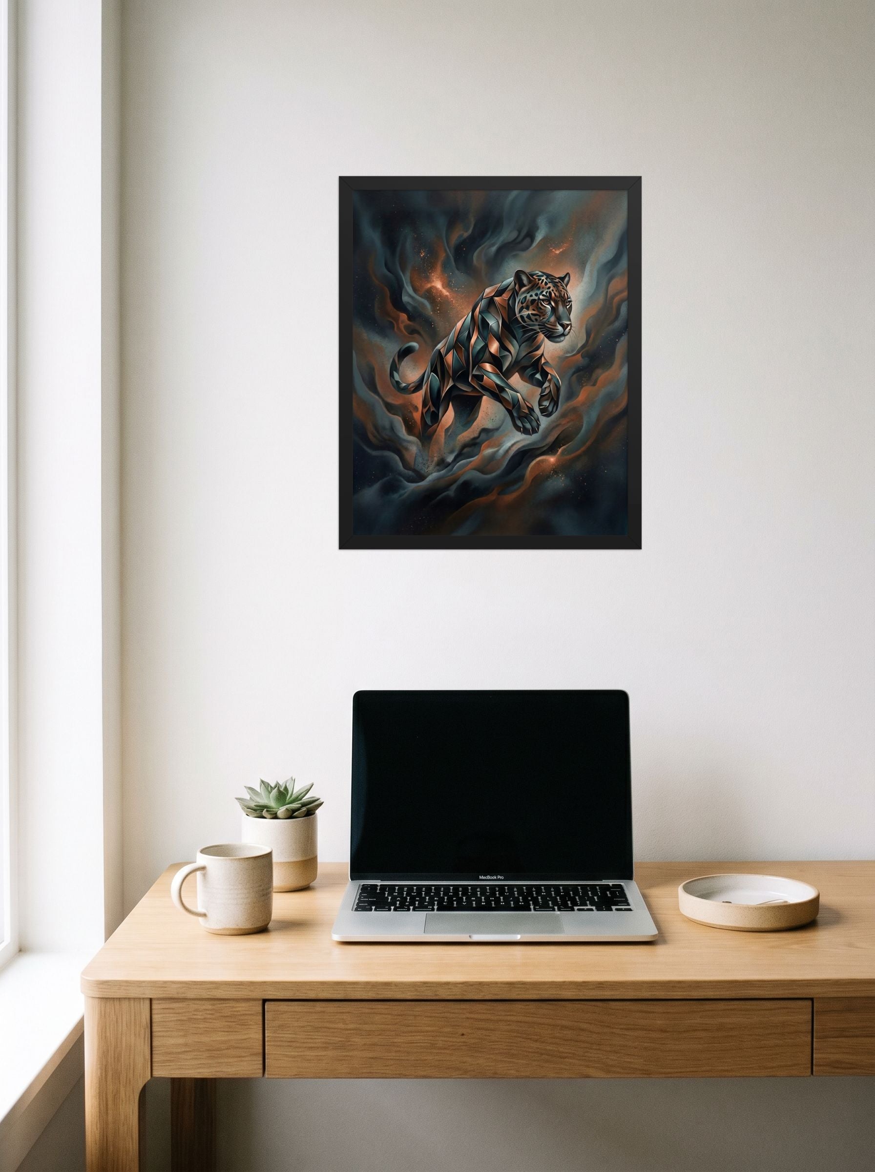 A 16x20 inch black framed Digital art print of 'Phantom Leap' hanging above a worktable with a laptop.