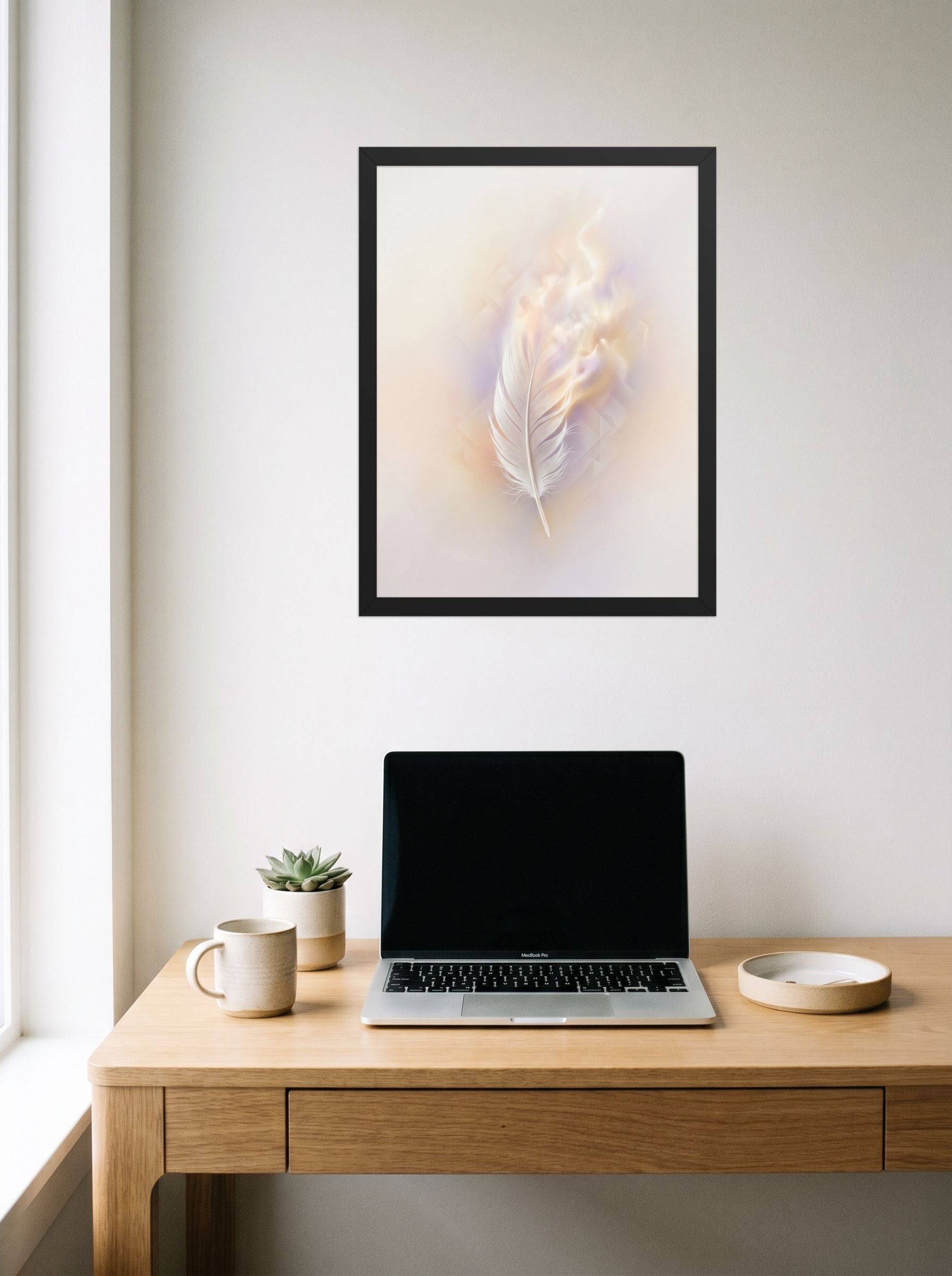 A 18x24 inch black framed Abstract art print of 'Ethereal Plume' hanging above a worktable with a laptop.