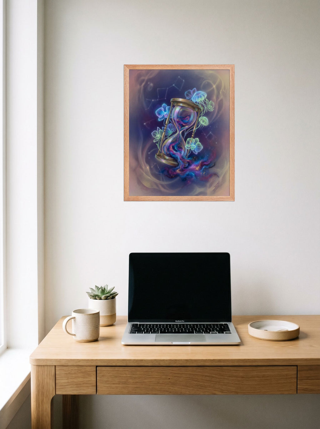 A 16x20 inch redoak framed Magic realism print of 'Sands of the Nebula' hanging above a worktable with a laptop.