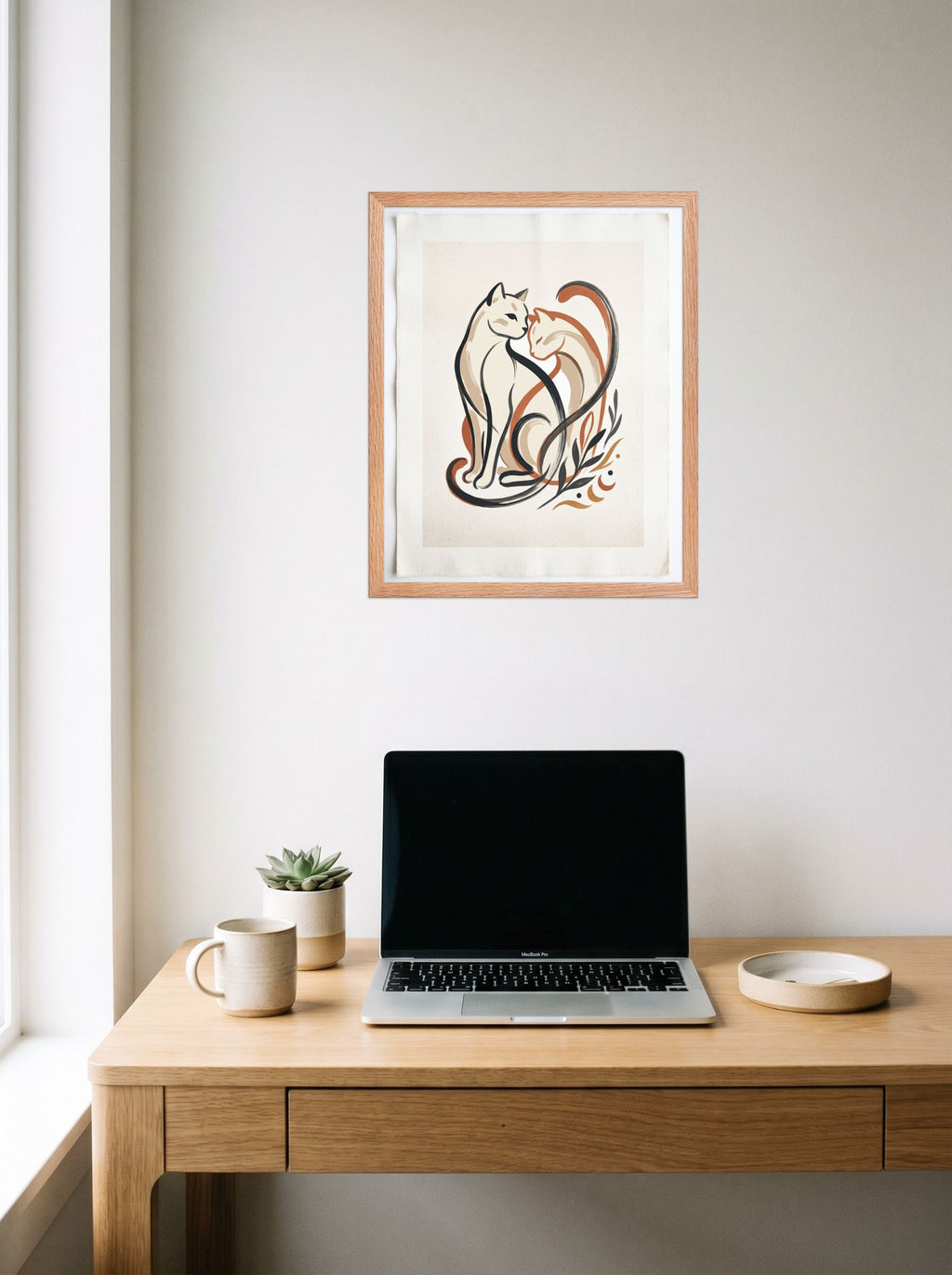 A 16x20 inch redoak framed Minimalism,Abstract art print of 'Feline Affection' hanging above a worktable with a laptop.