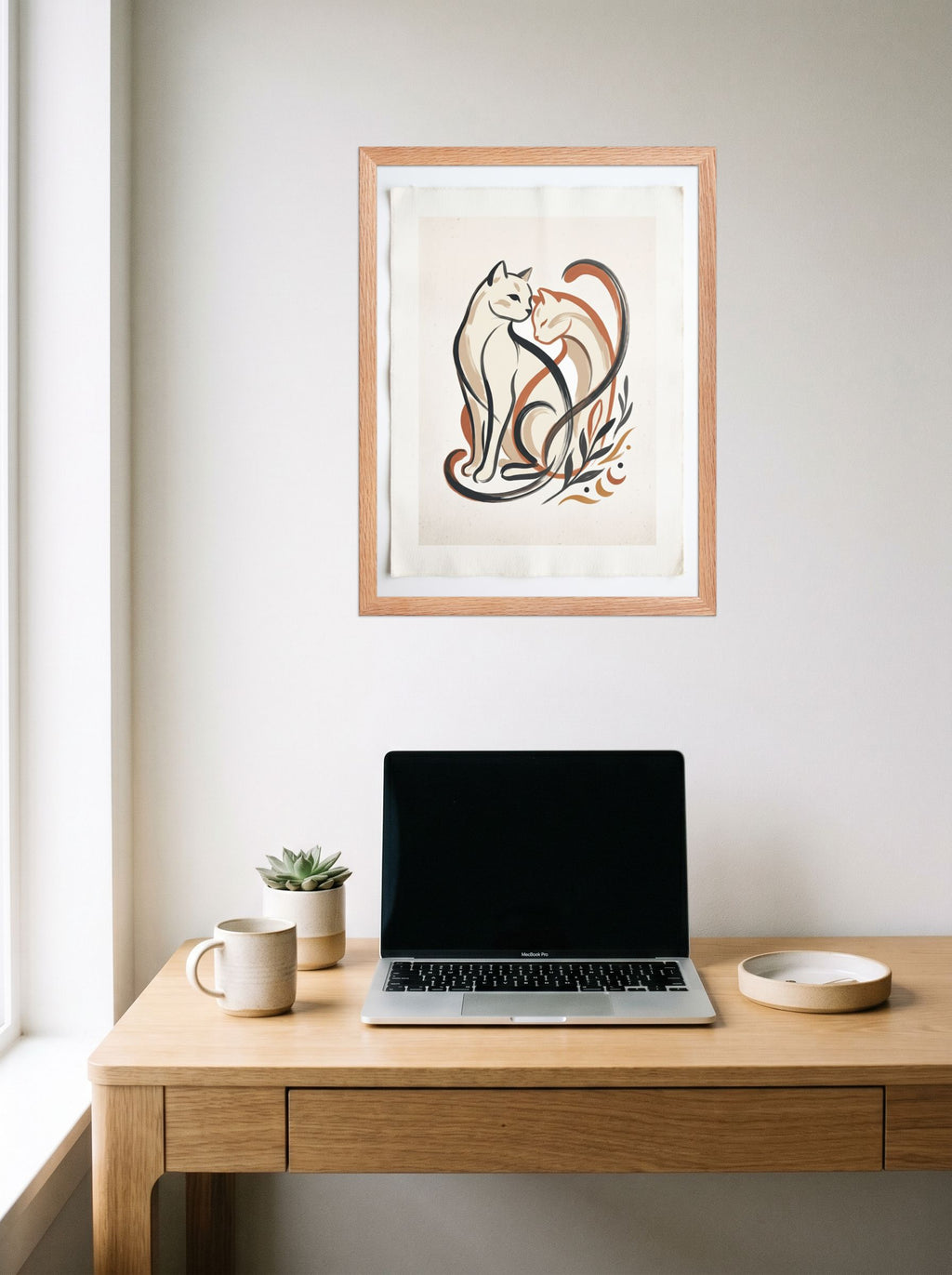 A 18x24 inch redoak framed Minimalism,Abstract art print of 'Feline Affection' hanging above a worktable with a laptop.