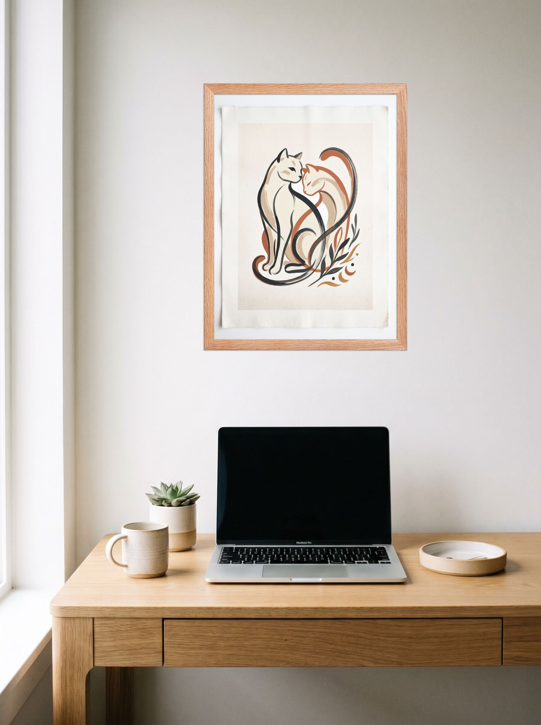 A 18x24 inch redoak framed Minimalism,Abstract art print of 'Feline Affection' hanging above a worktable with a laptop.