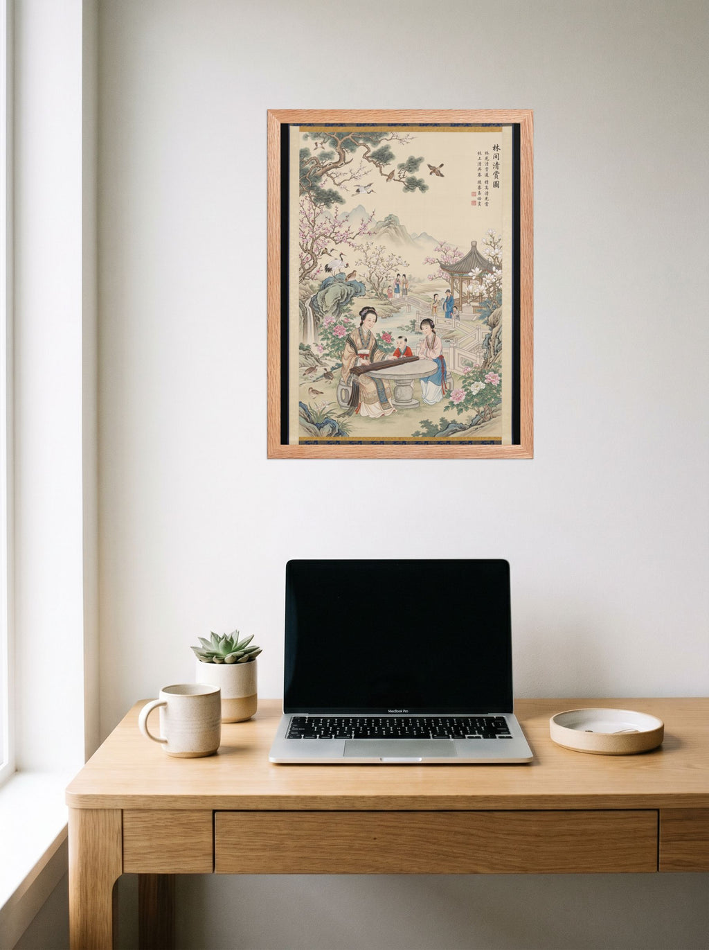 A 18x24 inch redoak framed Fine Art print of 'Melody in the Spring Garden' hanging above a worktable with a laptop.