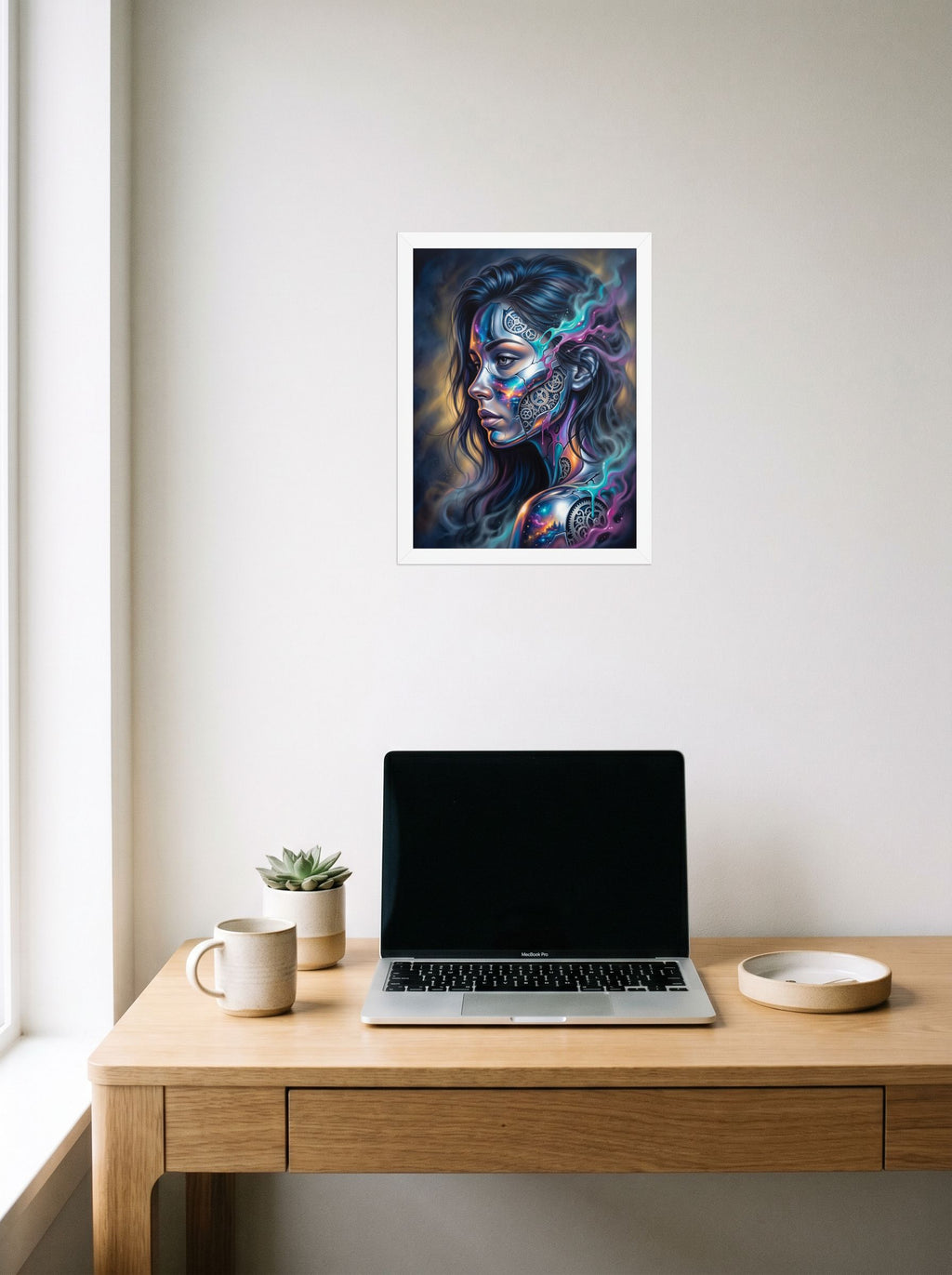 A 12x16 inch white framed Surrealism print of 'Cosmic Clockwork' hanging above a worktable with a laptop.