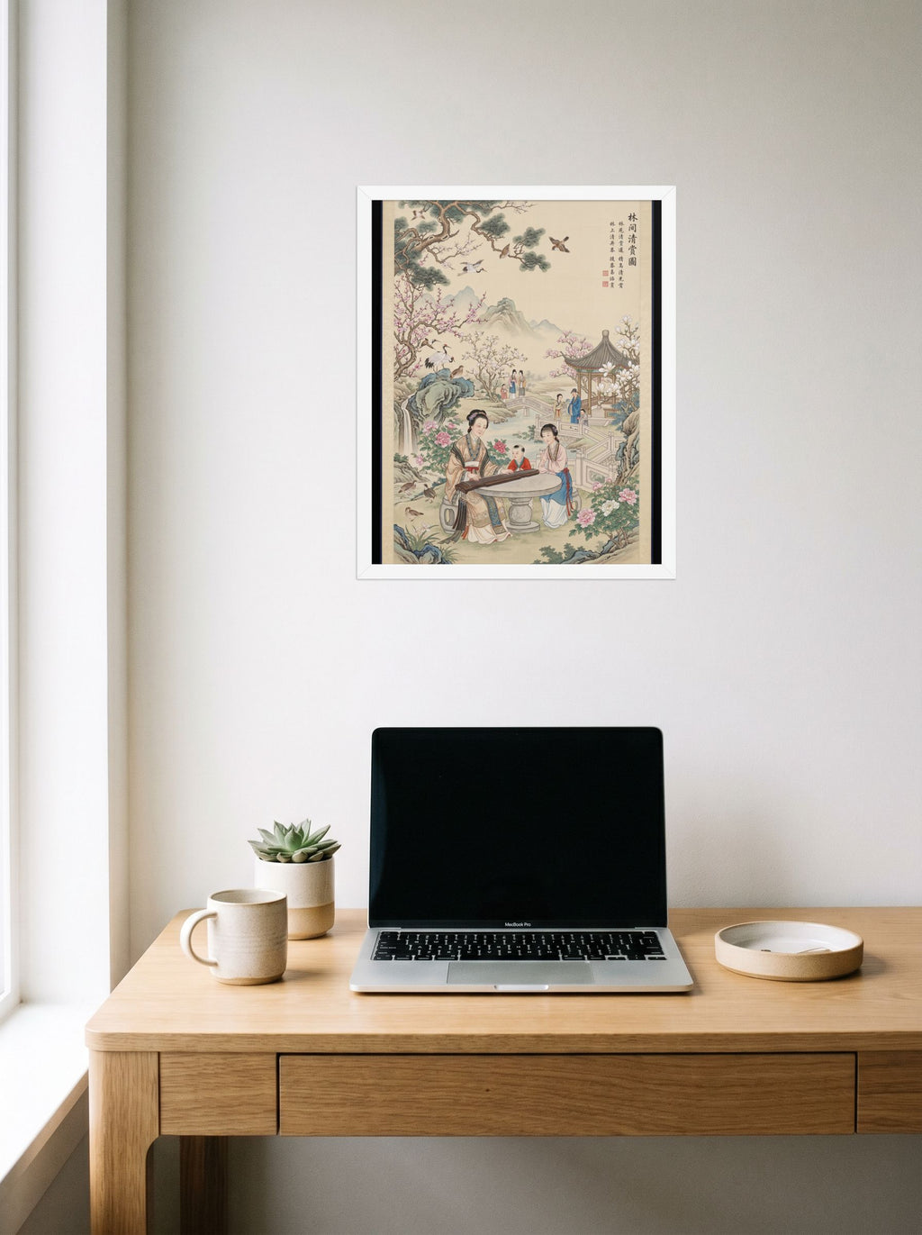 A 16x20 inch white framed Fine Art print of 'Melody in the Spring Garden' hanging above a worktable with a laptop.