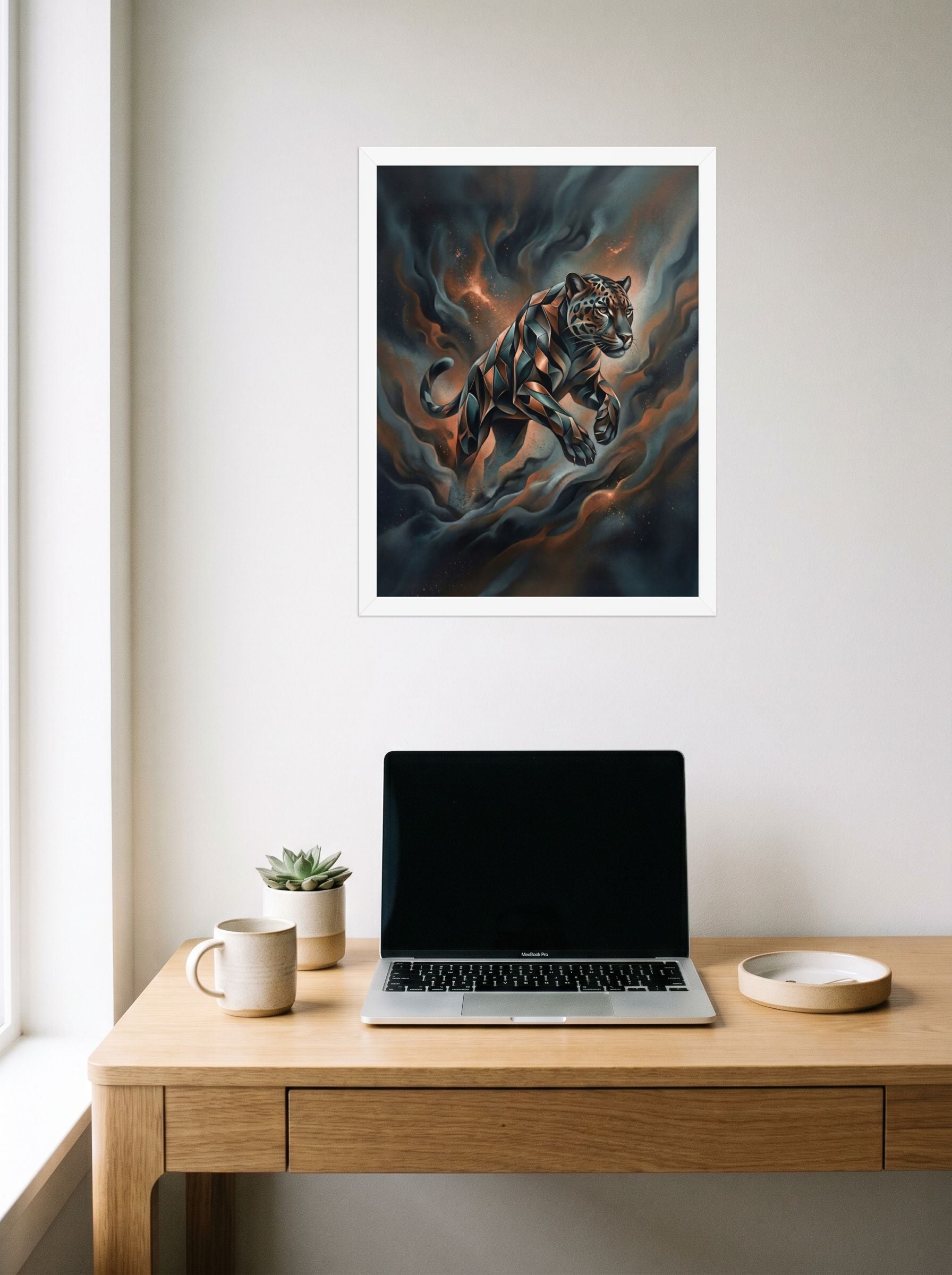 A 18x24 inch white framed Digital art print of 'Phantom Leap' hanging above a worktable with a laptop.