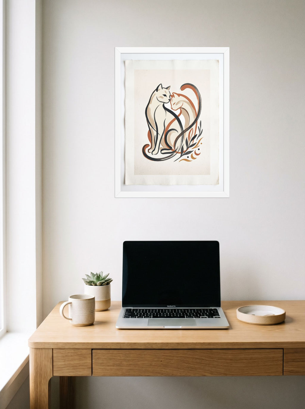 A 18x24 inch white framed Minimalism,Abstract art print of 'Feline Affection' hanging above a worktable with a laptop.