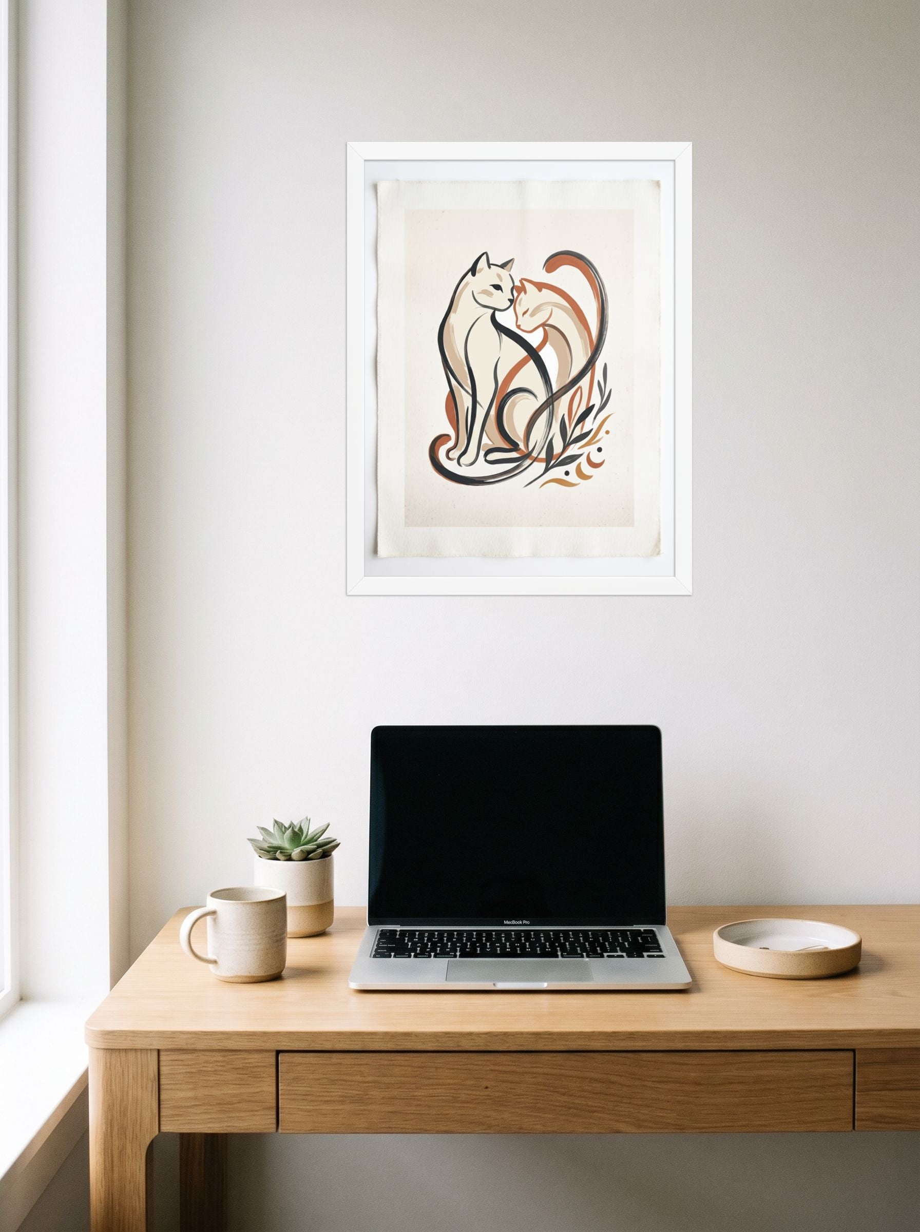 A 18x24 inch white framed Minimalism,Abstract art print of 'Feline Affection' hanging above a worktable with a laptop.